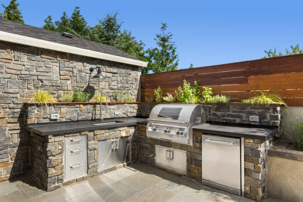Backyard hardscape entertainment area with outdoor kitchen design by BA Lawns and Landscaping